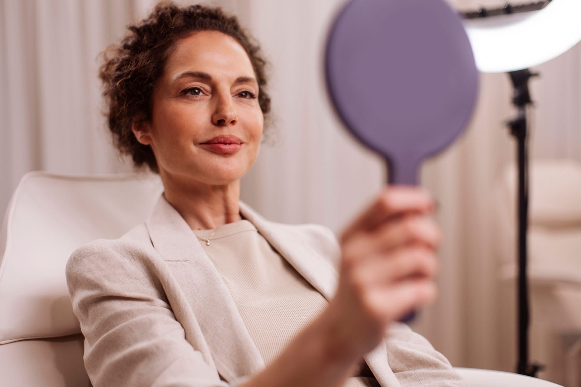 older woman looking in the mirror after her facelift in Milwaukee, WI