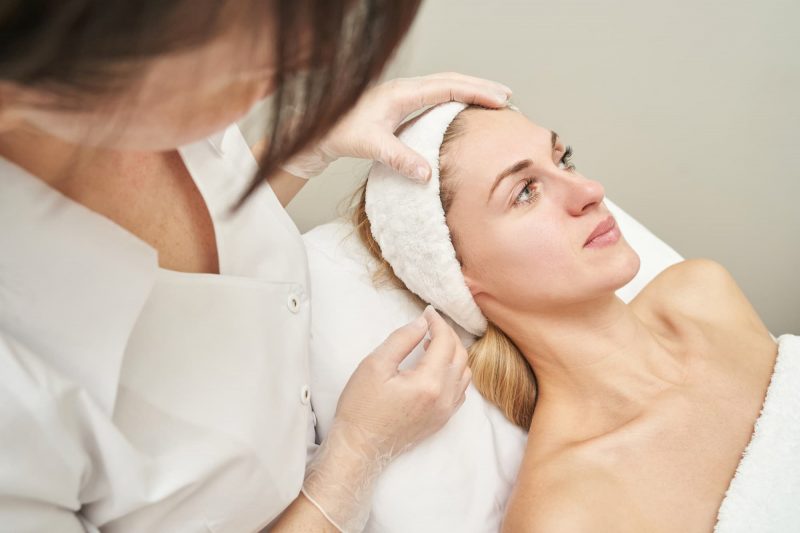 A consultation scene with a surgeon discussing whether a deep-plane facelift is the right choice for a patient experiencing sagging skin or deep wrinkles.